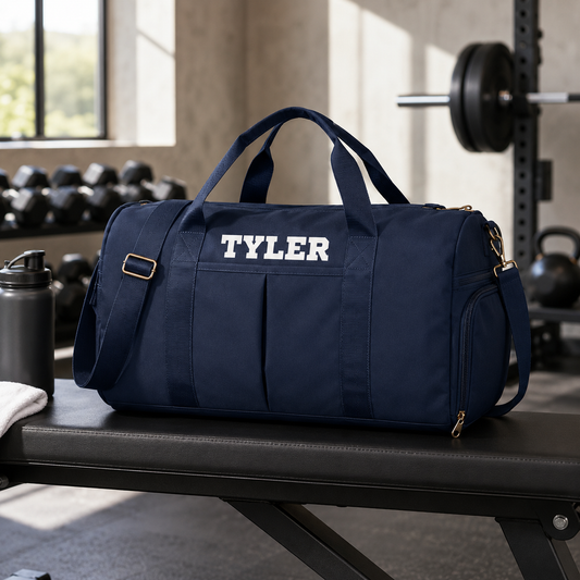 Navy duffel bag with 'TYLER' on it in a gym setting