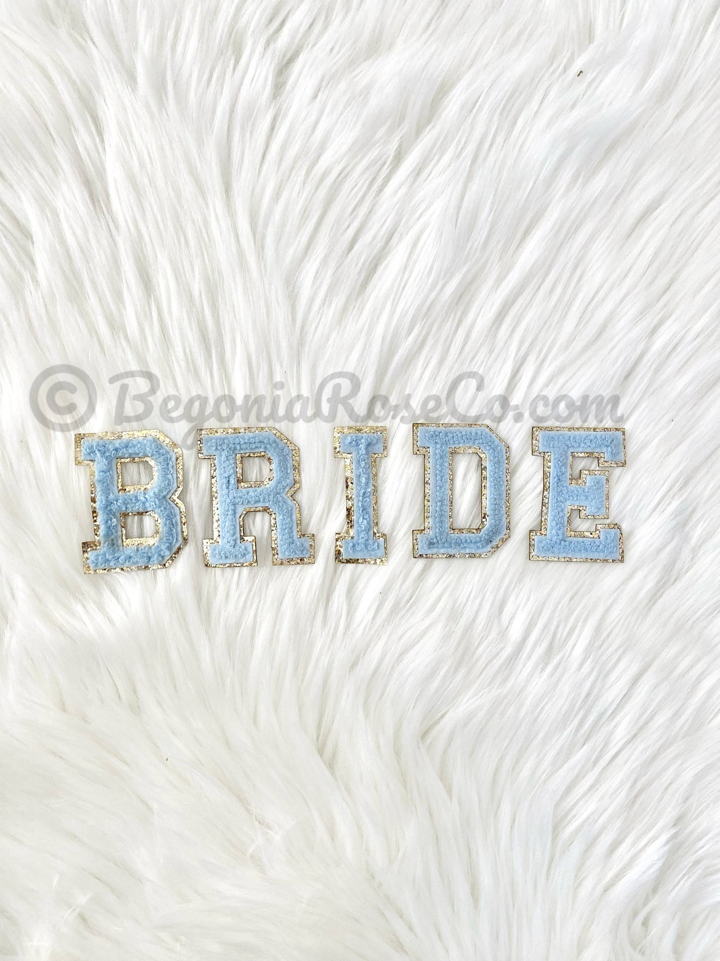 Chenille letter patches in pink on white textured background