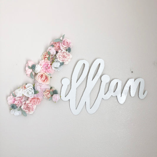 Pink silk flower covered first letter joined to a white script wood name sign