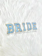 Chenille letter patches in pink on white textured background