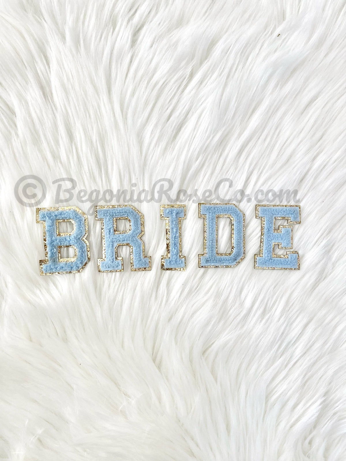 Chenille letter patches in pink on white textured background