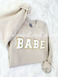 BABE patch sweatshirt front view showing elastic cuffs and waistband detail