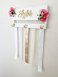 Wood bow storage with custom name and floral embellishments