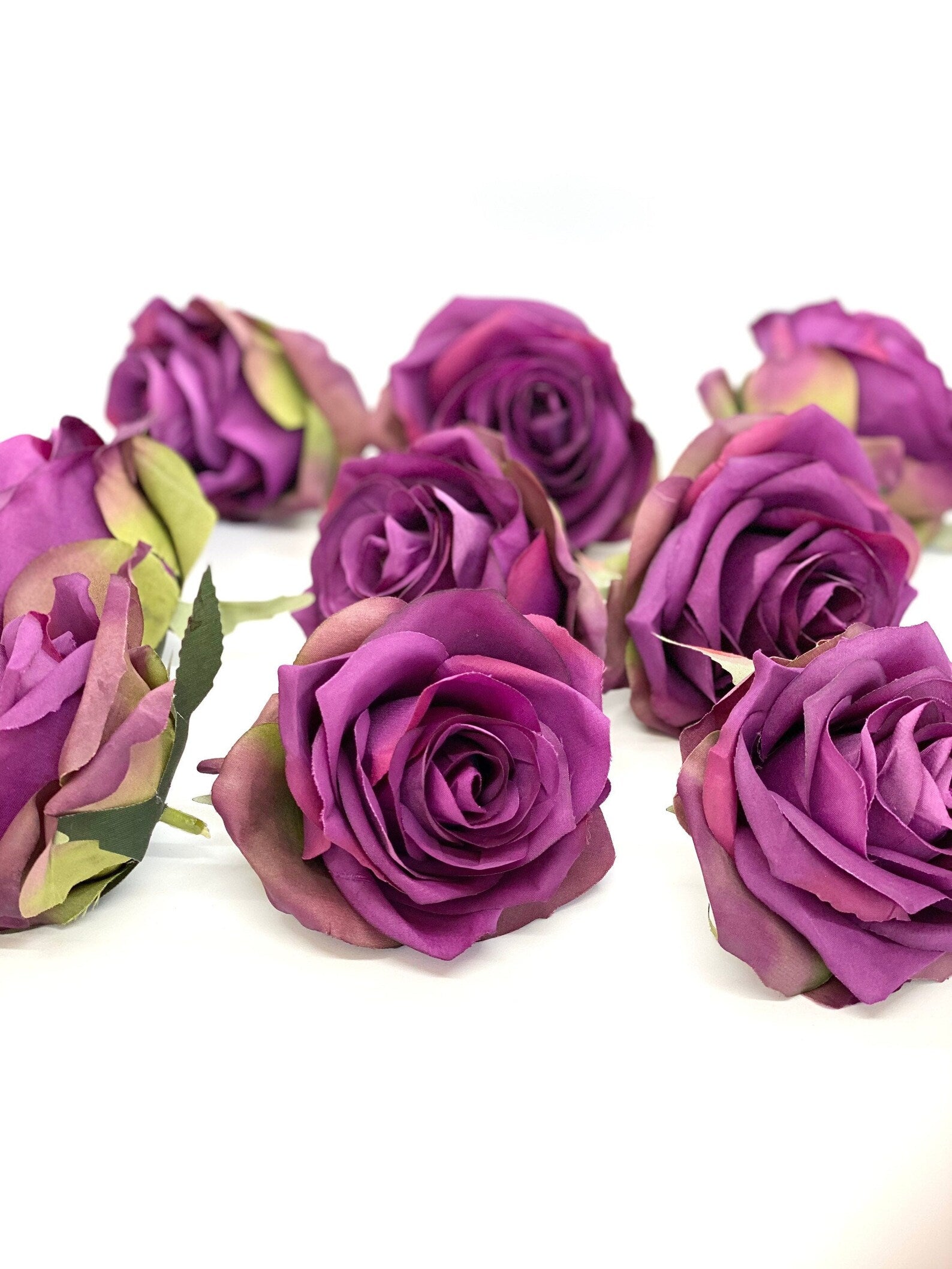 Warm purple artificial rose close up showing realistic petal variation for decor