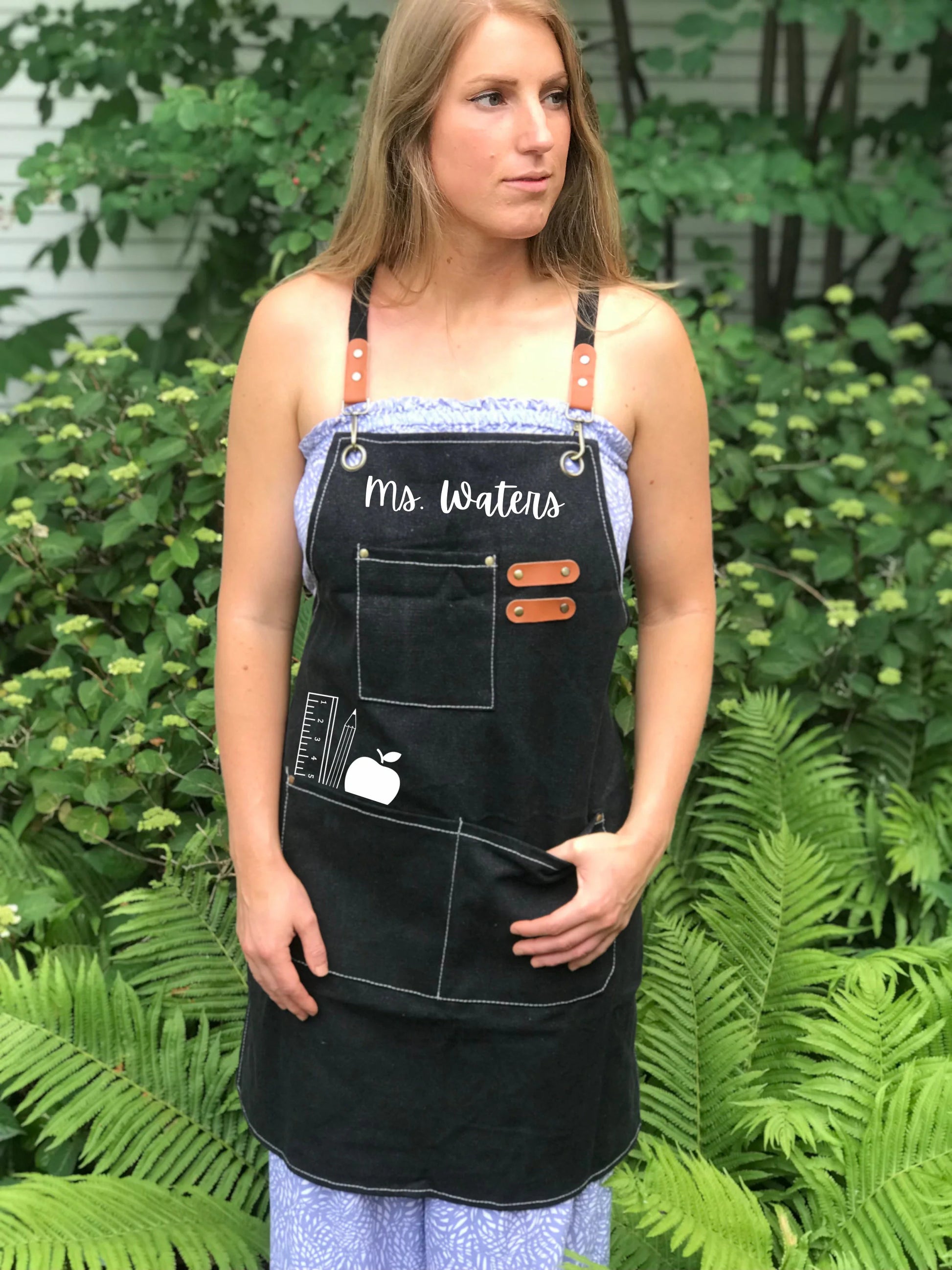 Teacher apron with pockets worn in classroom cross-back smock