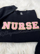 Model wearing chenille NURSE patch crewneck sweatshirt in grey - nurse birthday gift