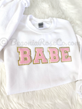 Chenille BABE patch crewneck sweatshirt in white with light pink letters - front view