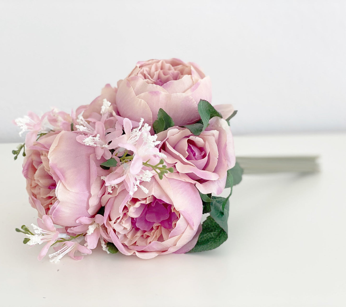 Artificial pink peony bouquet side view showing full width faux flower arrangement