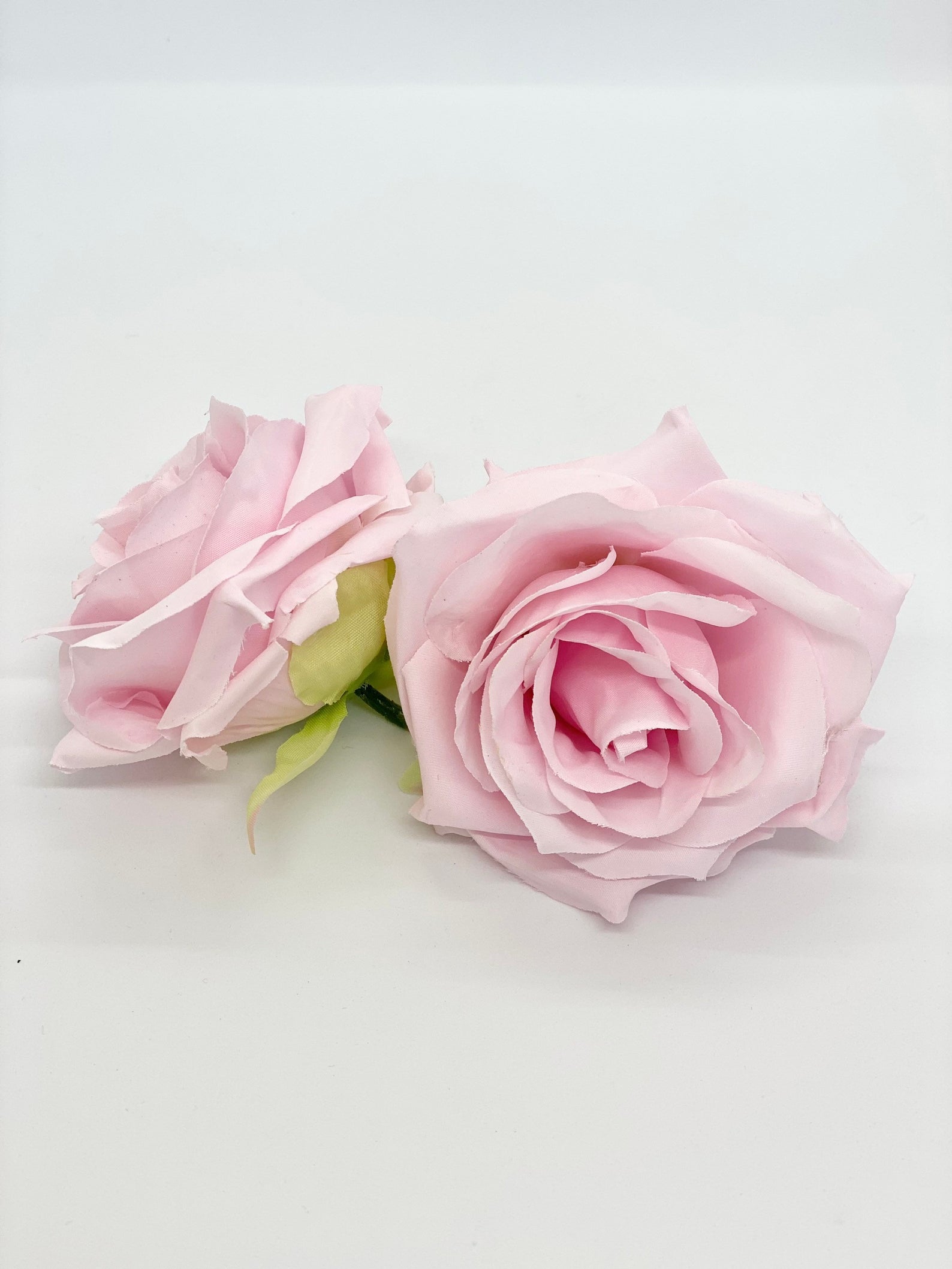 Light pink faux rose head close up showing darker blush center for crafts